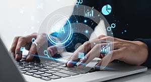 Hands typing on laptop with futuristic digital interface overlay data analytics technology