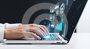 Hands typing on a laptop with glowing futuristic digital interface and data visualization elements