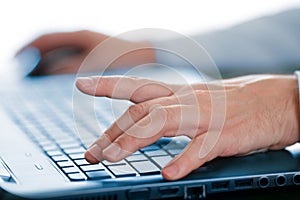 Hands typing on laptop keyboard