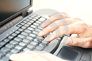 Hands typing on laptop keyboard