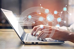 Hands typing on laptop keyboard with digital interface and network connections representing technology, data analysis