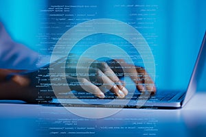 Hands typing on laptop with programming code overlay, blue background