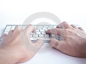 Hands typing on remote control wireless computer keyboard