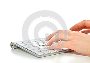 Hands typing on the remote wireless computer keyboard