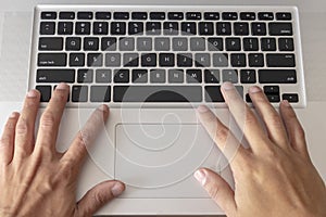Hands typing on computer keyboard