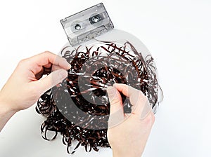 Hands uncurving audio tape