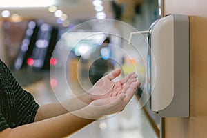 Hands under the automatic alcohol dispenser. Infection and hospitably concept. save and protect disease virus against germs and cl