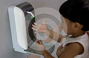 Hands under the automatic alcohol dispenser. Infection and hospitably concept. save and protect disease virus against germs and cl