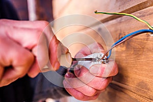 Hands of unrecognizable electrician working with screwdriver