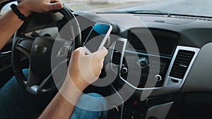 Hands of unrecognizable man driver using mobile phone while driving car, slow motion video