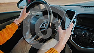 Hands of unrecognizable woman driver using mobile phone while driving car, slow motion video