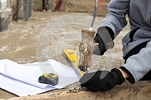 Hands of unrecognizable woman nailing with a hammer and different tools around