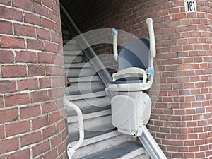 Hands up stairlift or chair lift at the bottom of the ground floor stairway