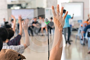 Hands up for vote on meeting blurred background