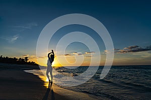 Hands up woman posing on the beach with beautiful sunset sky, clouds background. Free space for text. Cuba Varadero Yoga