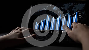 Hands of a user interacting with data visualization on a laptop screen, displaying analytics charts, graphs, and