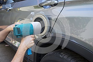 Hands using auto polisher on the body car photo