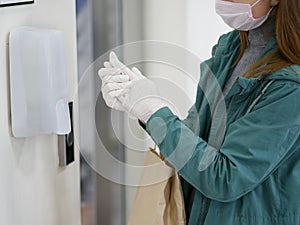 Hands using automatic sanitizer dispenser at supermarket. Disinfectant in a shopping mall during the coronavirus