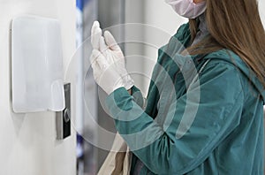 Hands using automatic sanitizer dispenser at supermarket. Disinfectant in a shopping mall during the coronavirus