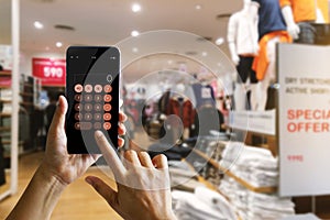 Hands using calculator application on mobile smartphone.