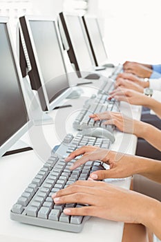 Hands using computers in office