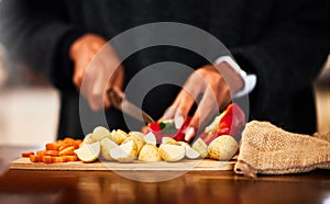 Hands, vegetables and knife on board for prepare in home with raw ingredients with kitchen chef, food and health