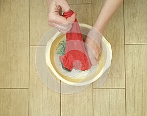 Hands washing housewife color clothes in basin