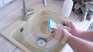 Hands washing pet lick mat in kitchen sink