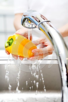 Hands washing a vegetable