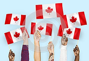 Hands waving flags of Canada