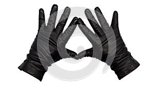 Hands wearing black leather gloves making a diamond or kite frame between thumb and index finger with fingers splayed, palms down.