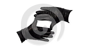 Hands wearing black leather gloves making a square or rectangle frame between thumb and index finger with fingers together.  Femal