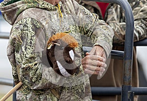 Hands of a weathered rancher holding a toy stick horse