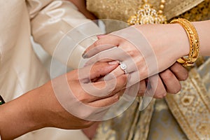 hands of a wedding couple, Groom put a ring on finger of his lov