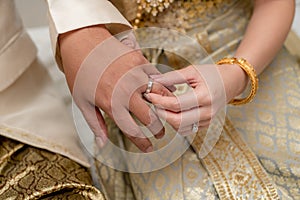 hands of a wedding couple, Groom put a ring on finger of his lov