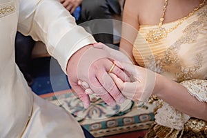 Hands of a wedding couple, Groom put a ring on finger of his lovely wife, wedding ceremony