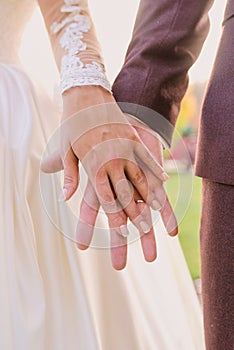 Hands of wedding couple in love.