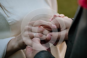 Hands, wedding couple and ring at outdoor ceremony