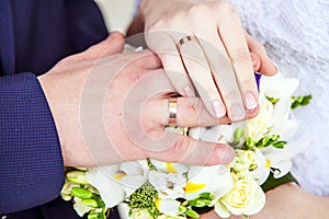 Hands with wedding rings and bouquet