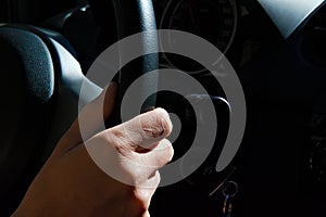 Hands on the wheel of a black car