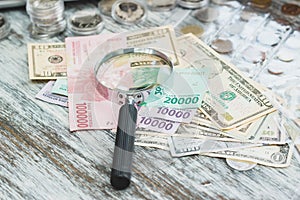 Hands in white gloves, different American dollars and Indonesian rupiahs, numismatics concept