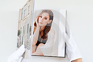 Hands in white gloves flipping through a photo book with wedding photos