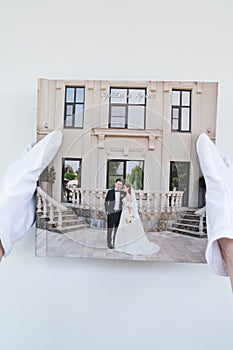 Hands in white gloves holding a photo book with wedding photos