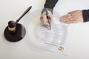 Hands of wife, husband signing decree of divorce, dissolution, canceling marriage, legal separation documents, filing