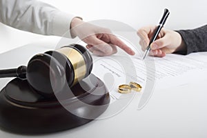 Hands of wife, husband signing decree of divorce, dissolution, canceling marriage, legal separation documents, filing