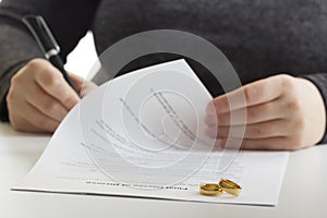 Hands of wife, husband signing decree of divorce, dissolution, canceling marriage, legal separation documents, filing