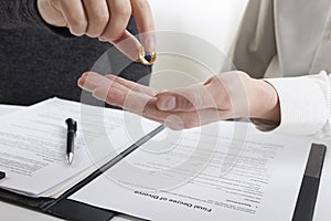 Hands of wife, husband signing decree of divorce, dissolution, canceling marriage, legal separation documents, filing