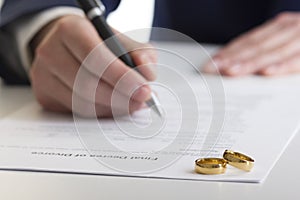 Hands of wife, husband signing decree of divorce, dissolution, canceling marriage, legal separation documents, filing