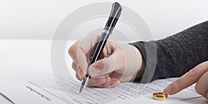 Hands of wife, husband signing decree of divorce, dissolution, canceling marriage, legal separation documents, filing