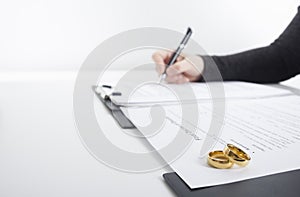 Hands of wife, husband signing decree of divorce, dissolution, canceling marriage, legal separation documents, filing